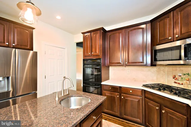 a view of an empty room with wooden floor and windows