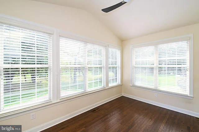 a view of a hallway with wooden floor and stairs