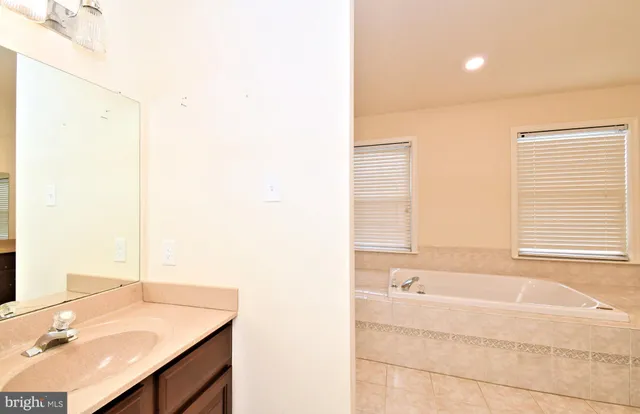 a view of an empty room with wooden floor and windows