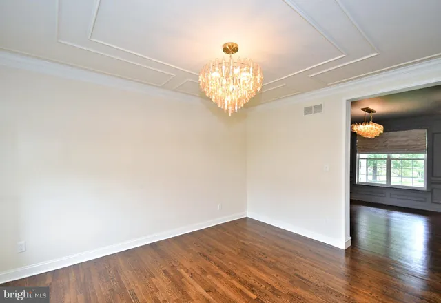 a view of a room with wooden floors and chandelier