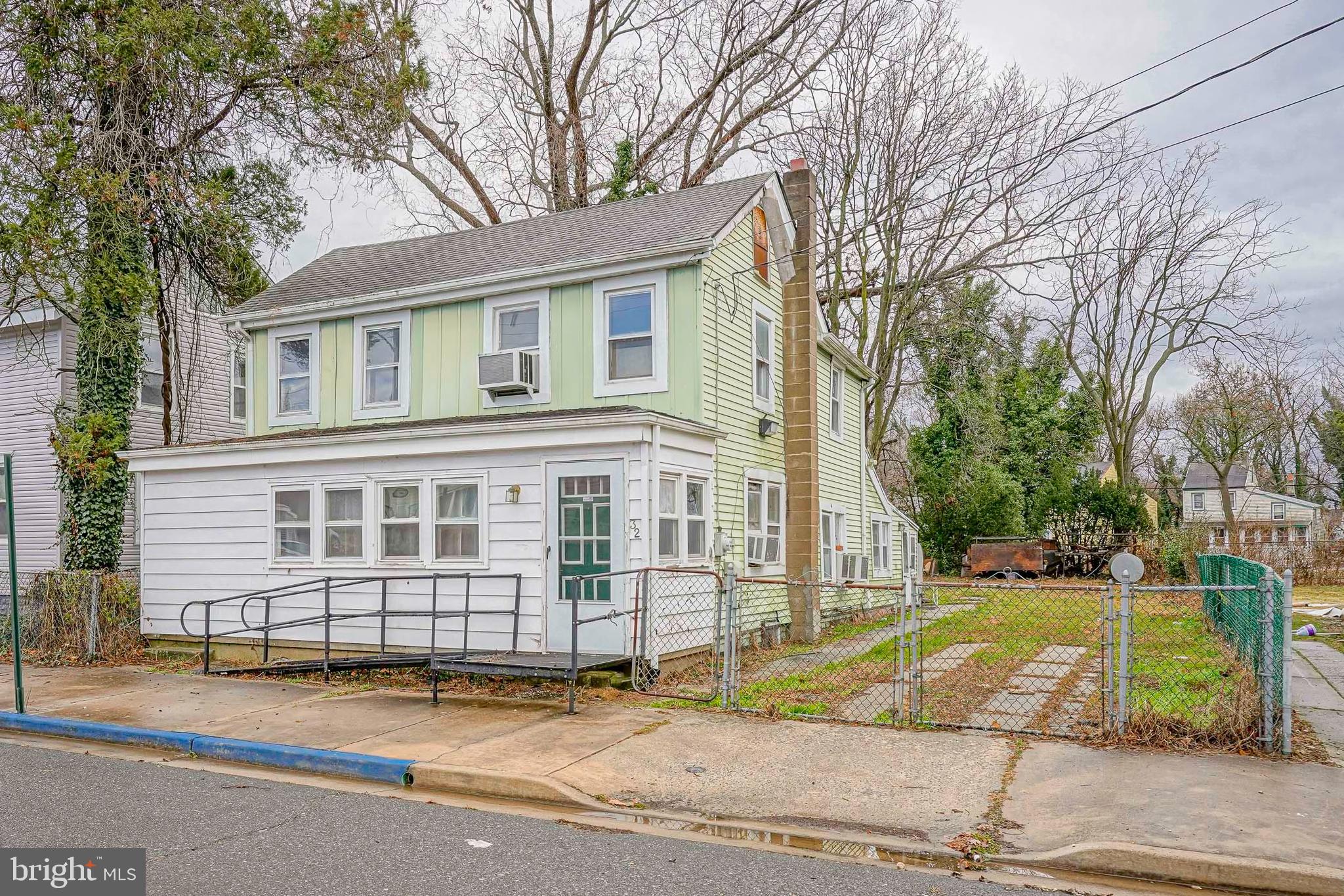 4 Oak Street Salem, NJ 08079 - Photo 2 of 34 a view of a white house with large windows and a small yard
