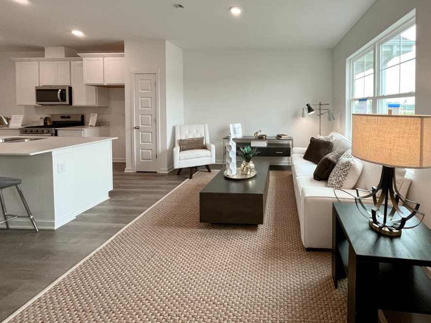 2116 Bodega Drive Oswego, IL 60543 - Photo 17 of 36 a living room with stainless steel appliances furniture a rug kitchen view and a window