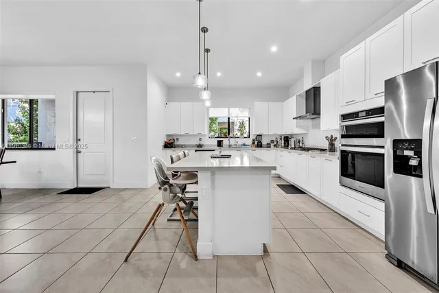 a kitchen with stainless steel appliances kitchen island granite countertop a sink and cabinets