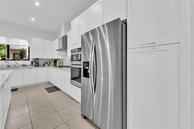 a kitchen with stainless steel appliances a refrigerator sink and microwave