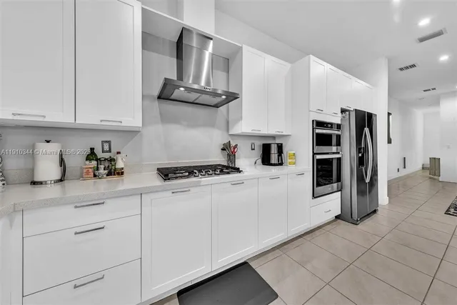 a kitchen with stainless steel appliances granite countertop a refrigerator sink and stove