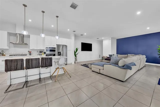 a living room with furniture and kitchen view