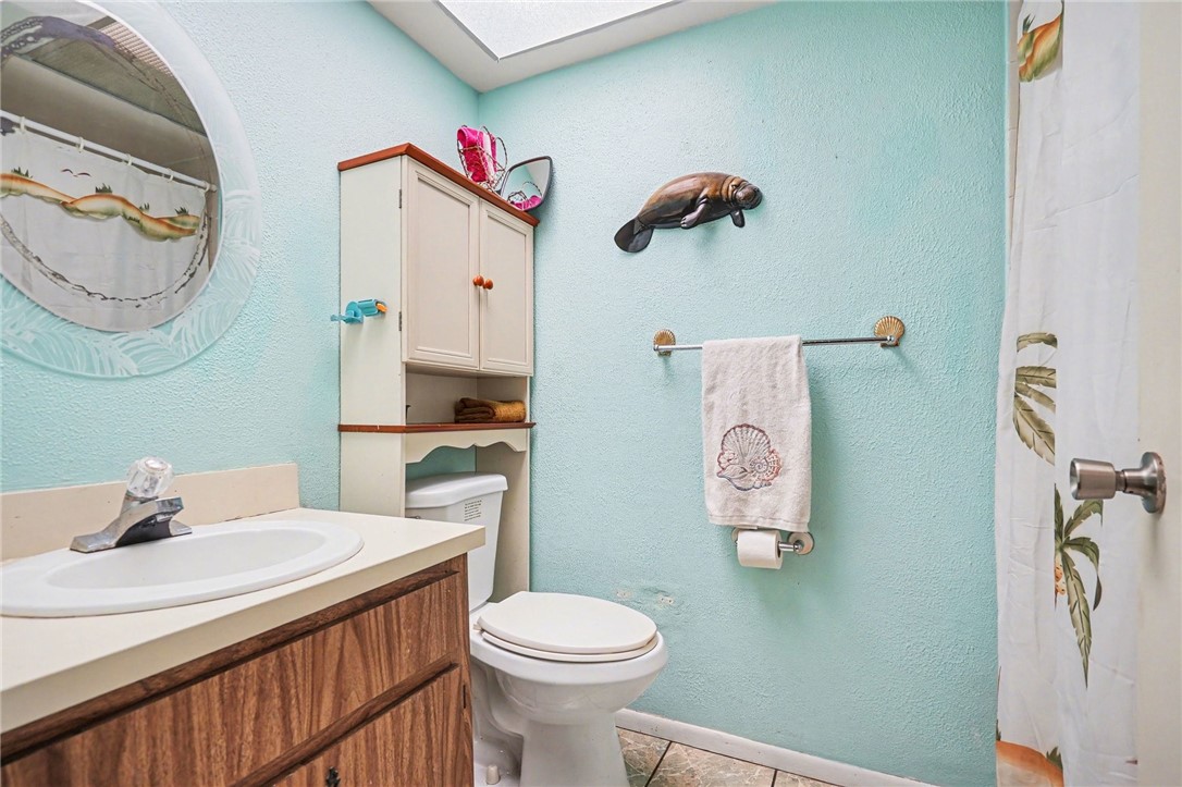 748 Cranbrook Avenue Northeast Palm Bay, FL 32905 - Photo 21 of 26 a bathroom with a sink mirror vanity and toilet