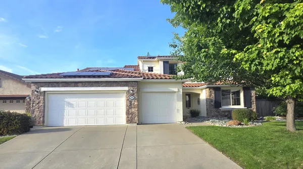 a front view of a house with a yard and garage