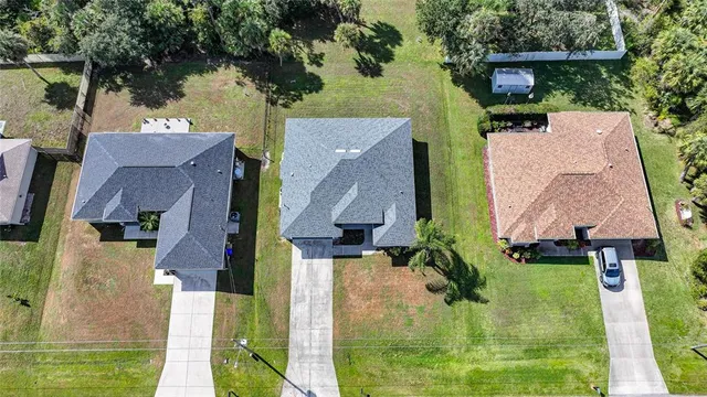 an aerial view of residential houses with outdoor space and swimming pool