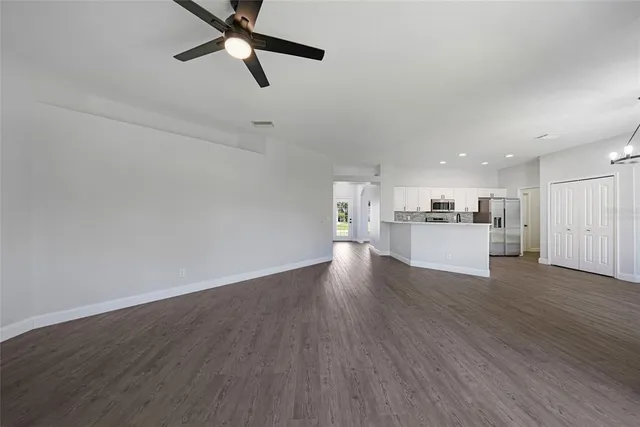 a kitchen with a dining table chairs and refrigerator