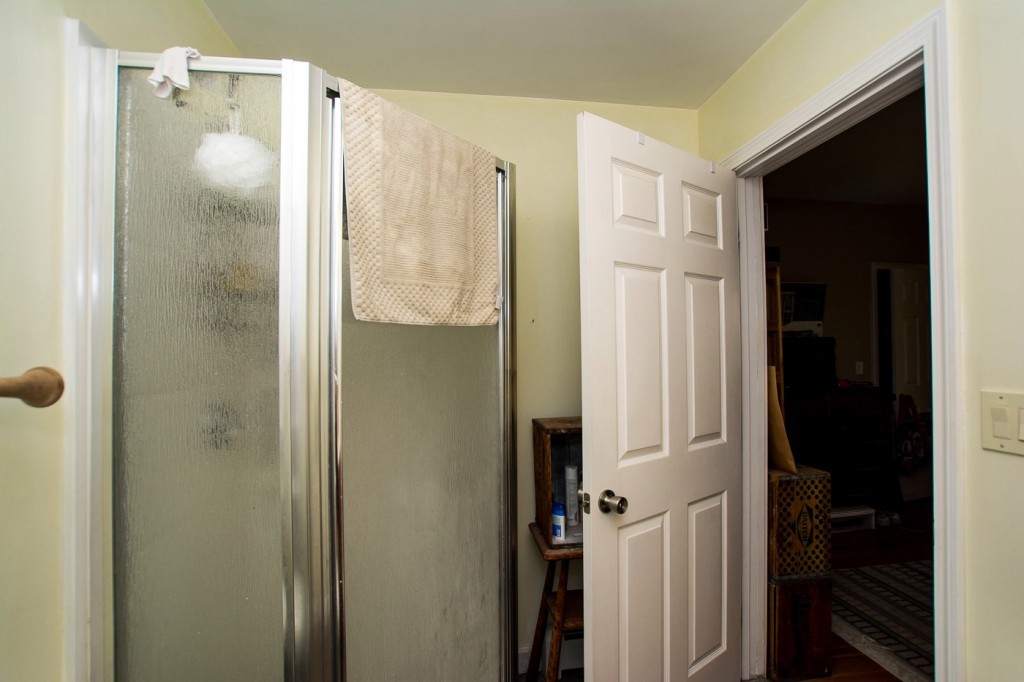 228 Langley Road Newton, MA 02459 - Photo 13 of 30 a bathroom with a glass shower door and a sink