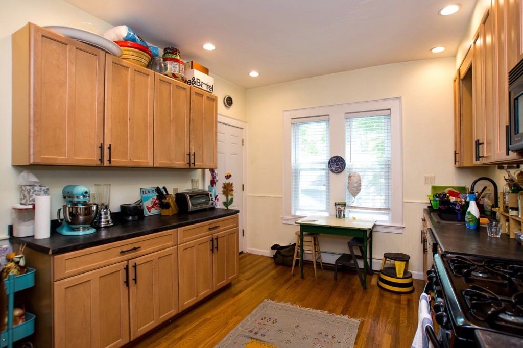 228 Langley Road Newton, MA 02459 - Photo 4 of 30 a kitchen with stainless steel appliances a stove a sink and cabinets