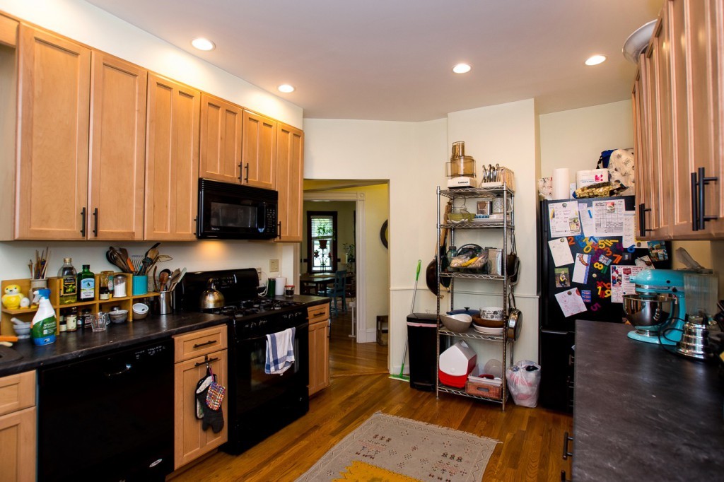 228 Langley Road Newton, MA 02459 - Photo 5 of 30 a kitchen with stainless steel appliances granite countertop a refrigerator a stove top oven and sink with wooden floor