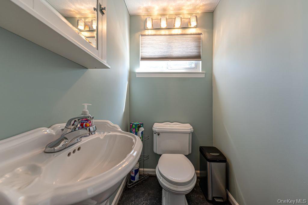 89 Cheltenham Road West Babylon, NY 11704 - Photo 12 of 26 a white toilet sitting next to a bathroom sink