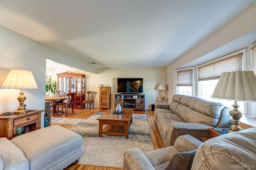 89 Cheltenham Road West Babylon, NY 11704 - Photo 7 of 26 a living room with furniture flat screen tv and a large window