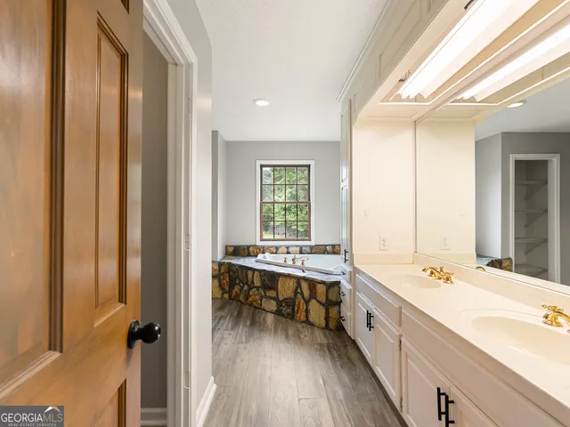 a white bath tub sitting in a bathroom next to a window