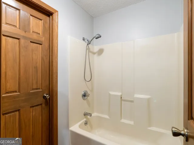 an empty room with windows and ceiling fan