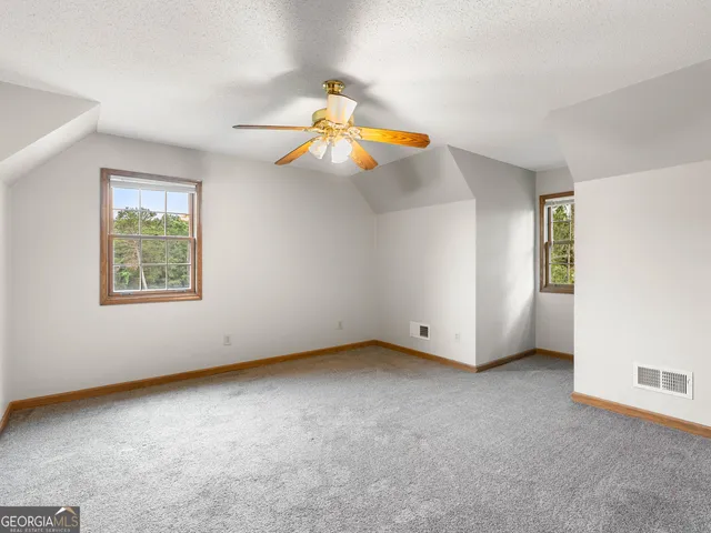 a view of an empty room with glass door and wooden floor