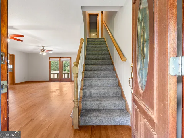 a view of an empty room with window and wooden floor