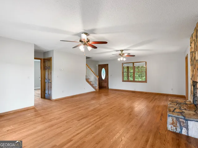 a view of a livingroom with a hardwood floor and a ceiling fan