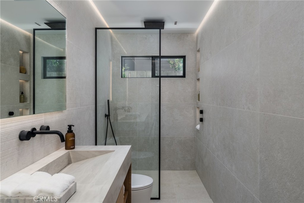 5826 Soledad Mountain Road La Jolla, CA 92037 - Photo 23 of 52 a bathroom with a tub shower sink and a mirror