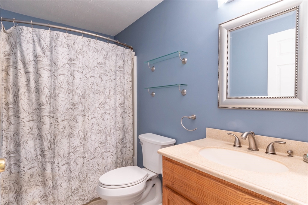 30 Lochmere Lane, Unit 30 Nashua, NH 03063 - Photo 14 of 19 a bathroom with a sink a toilet and a mirror