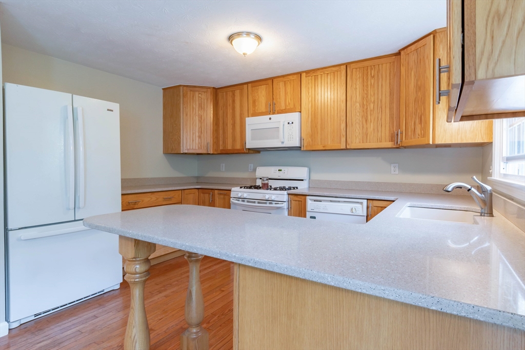 30 Lochmere Lane, Unit 30 Nashua, NH 03063 - Photo 8 of 19 a kitchen with stainless steel appliances a refrigerator a sink a stove a counter space and cabinets