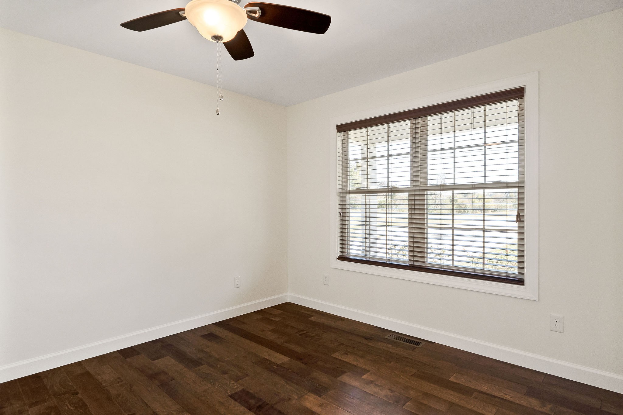7060 Ditty Road Cookeville, TN 38506 - Photo 7 of 35 an empty room with wooden floor cabinet and windows