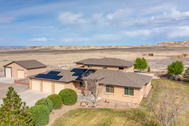 an aerial view of residential houses with outdoor space and ocean