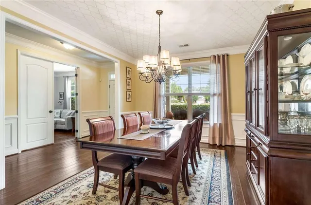 a dining room with furniture a chandelier and wooden floor