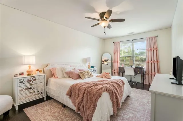 a bedroom with bed tv and a window