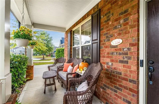 a view of a porch with chairs and potted plants