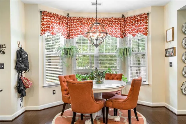 a dining room with furniture a chandelier and wooden floor