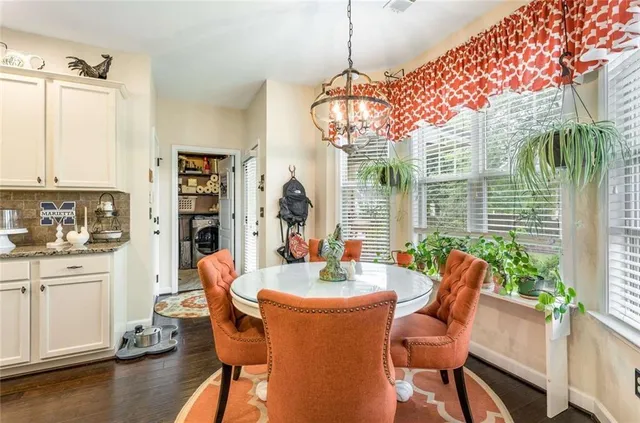 a dining room with furniture a chandelier and wooden floor