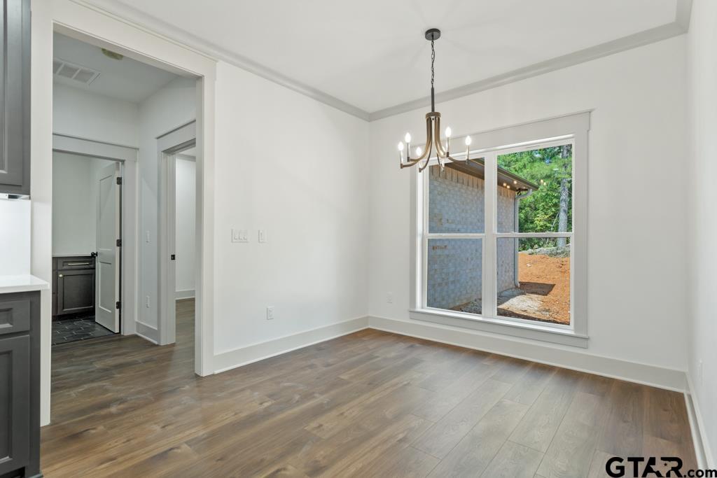 15837 Stillwaters Lindale, TX 75771 - Photo 12 of 32 an empty room with wooden floor wooden floor and windows