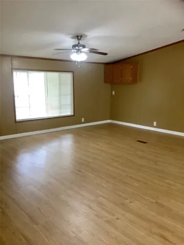 an empty room with windows and fireplace