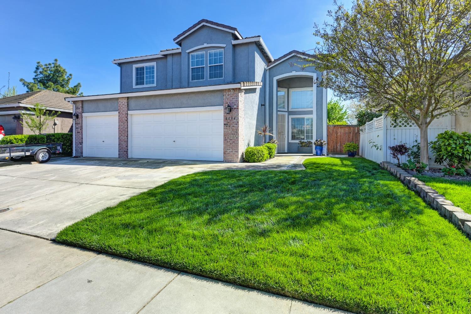 Front of house offers beautiful two-story home with 3 car Garage, 4 spaces in paved driveway, & nicely manicured front yard.