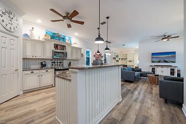 a kitchen with kitchen island granite countertop a sink appliances cabinets and a counter top space