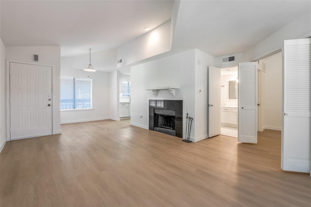 5550 Spring Valley Road, Unit D31 Dallas, TX 75254 - Photo 10 of 20 a view of empty room with wooden floor and fireplace