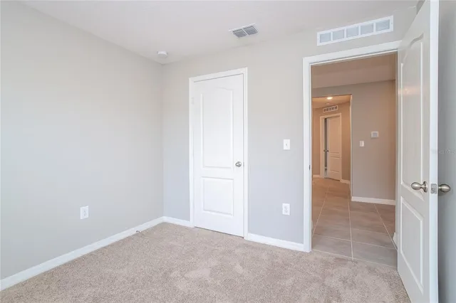an empty room with closet and a bathroom