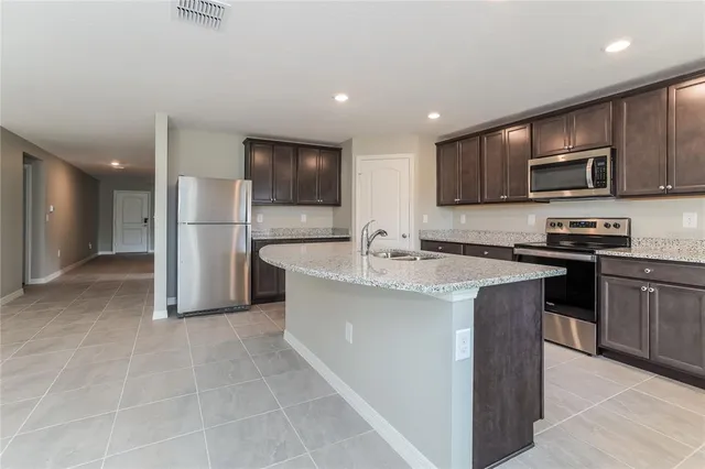 a kitchen with stainless steel appliances a sink stove and refrigerator