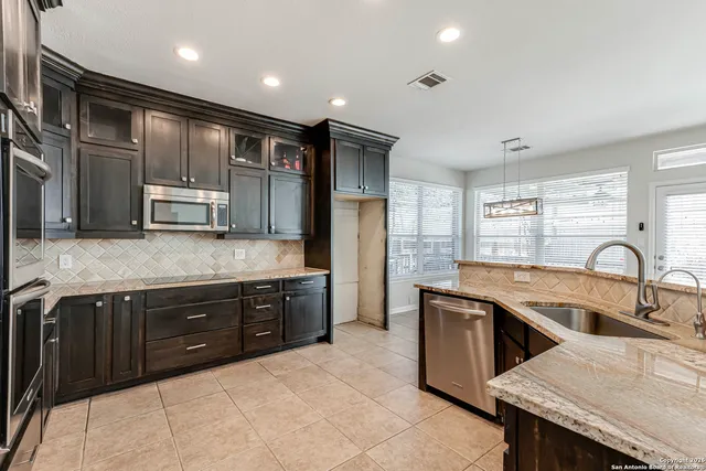 a kitchen with stainless steel appliances granite countertop a sink and a stove