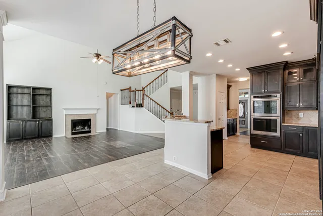 a view of a livingroom with kitchen and fireplace