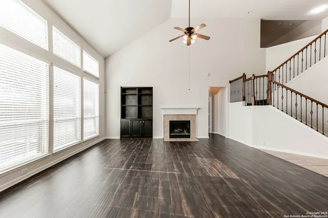 a view of empty room with fireplace and fan