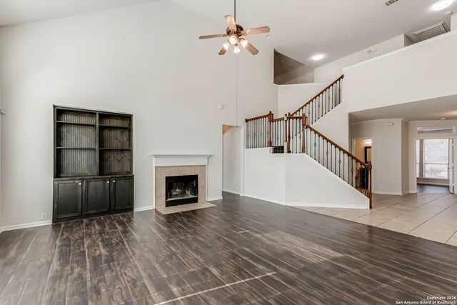 a view of a livingroom with a fireplace stairs and windows