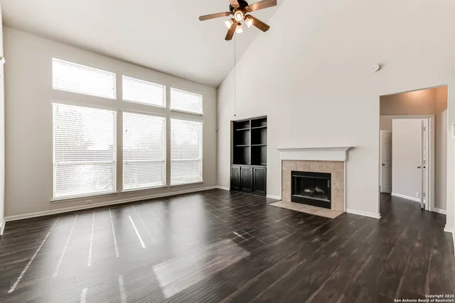 a view of empty room with wooden floor and fireplace