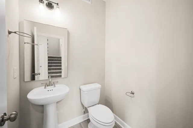 a bathroom with a toilet a sink and mirror