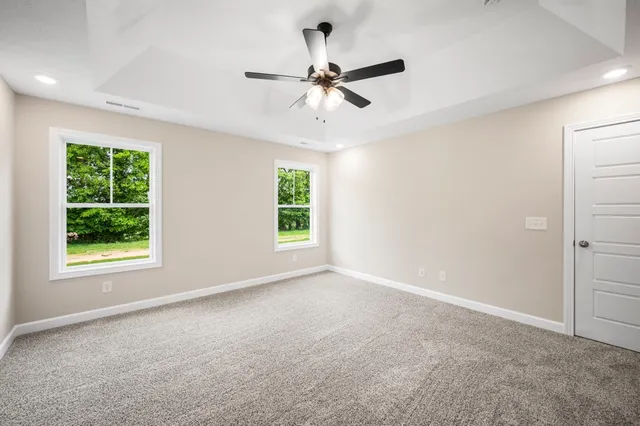 an empty room with a window and a fan