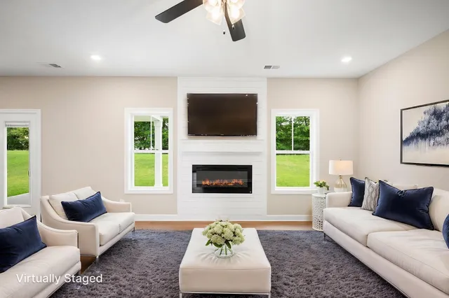 a living room with furniture a flat screen tv and a fireplace