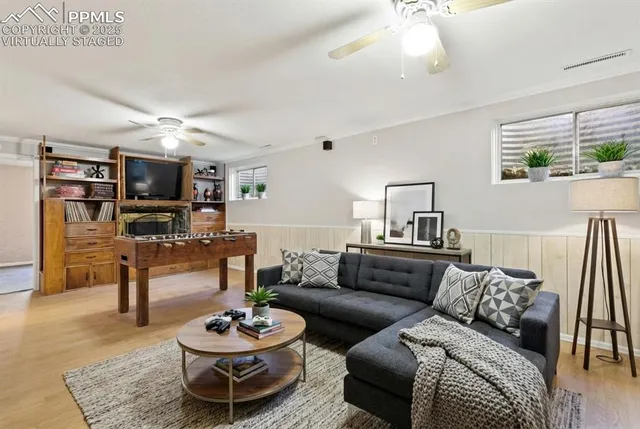 a living room with furniture a flat screen tv and kitchen view
